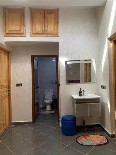 a bathroom with a toilet and a sink and a mirror at Chez houssam in Ouarzazate