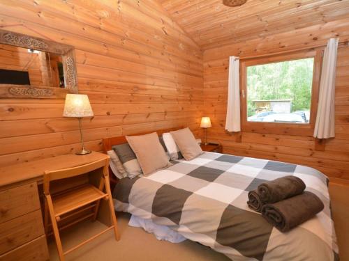a bedroom with a bed in a log cabin at 1 Bed in Tiverton oc-wonlo in Bampton