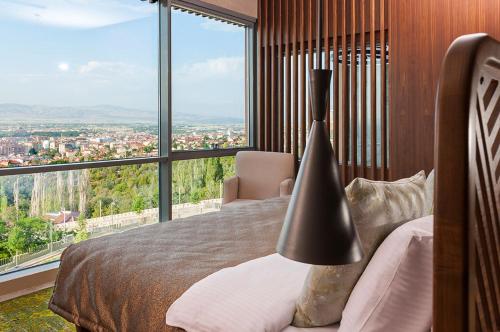 a bedroom with a bed and a large window at Tasigo Eskisehir in Eskisehir