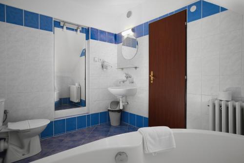 a bathroom with a tub and a sink and a toilet at Hotel Stara Posta in Filipovice