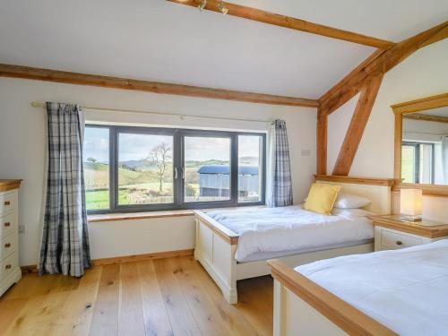 a bedroom with two beds and a large window at 5 Bed in Tiverton oc-48151 in Cadeleigh