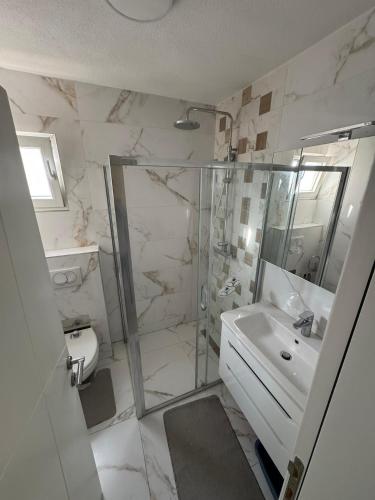 a white bathroom with a shower and a sink at The Urban Oasis in Bar
