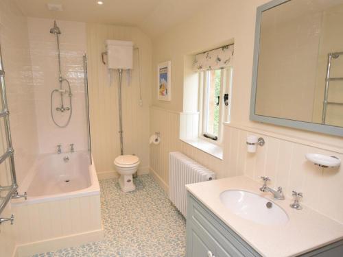 a bathroom with a sink and a tub and a toilet at 2 Bed in Stoke Abbott oc-50884 in Stoke Abbott
