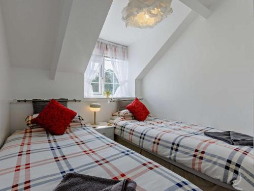 two beds in a attic room with red pillows at 2 Bed in Bideford oc-60430 in Westward Ho