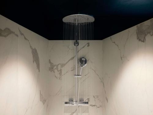 a shower in a bathroom with a black ceiling at Mercure Caen Centre Port De Plaisance in Caen