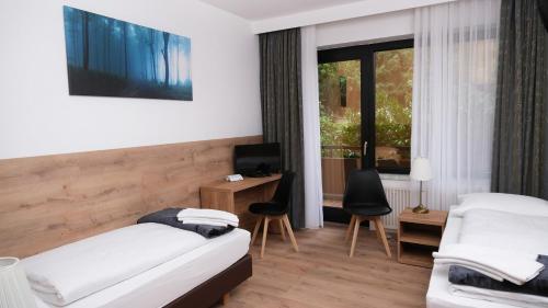 a bedroom with two beds and a desk with a computer at Forest Monteurzimmer & Fewo für Firmen & Gruppen in Bad Bevensen