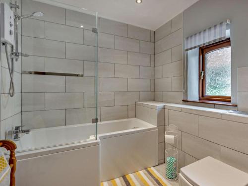 a white bathroom with a tub and a window at 3 Bed in Holsworthy oc-tcsheph in Merryfield