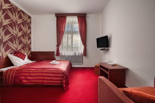 a hotel room with a bed and a window at Hotel Stara Posta in Filipovice