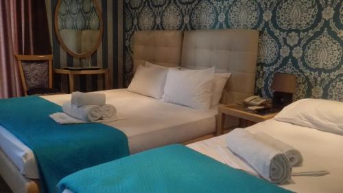 a hotel room with two beds with towels on them at Feevos in Piraeus