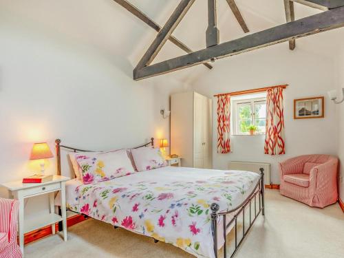 a bedroom with a bed and a pink chair at 3 Bed in Taunton oc-96235 in West Quantoxhead