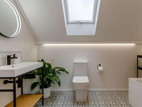 a bathroom with a toilet and a sink and a window at 3 Bed in Holsworthy oc-90721 in Holsworthy