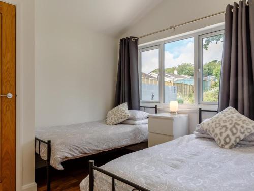 two beds in a room with a window at 2 Bed in Brixham oc-78565 in Brixham