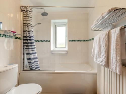 a white bathroom with a tub and a toilet at 2 Bed in Taunton oc-41906 in Cothelstone