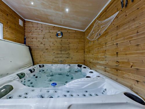 a jacuzzi tub in a room with wooden walls at 4 Bed in Bideford oc-nilga in Bideford