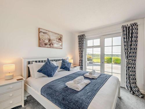 a bedroom with a bed with blue pillows and a window at 11 Bed in Bideford oc-redla in Instow