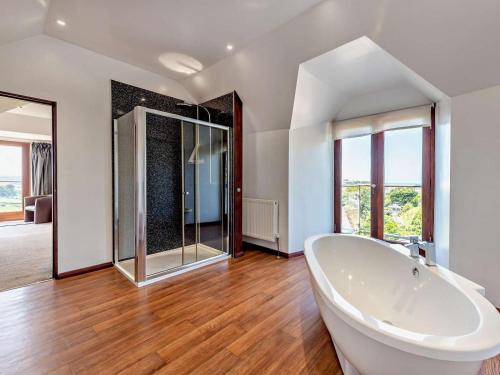 a large bathroom with a tub and a glass shower at 11 Bed in Bideford oc-redla in Instow