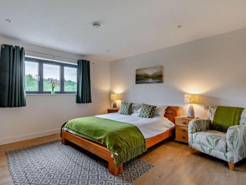 a bedroom with a bed and a chair and a window at 5 Bed in Dulverton oc-87003 in Morebath