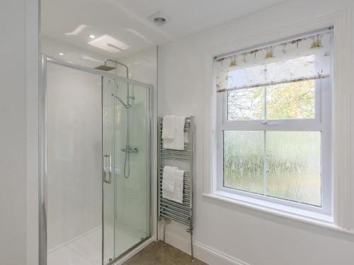 a bathroom with a glass shower and a window at 5 Bed in Holsworthy oc-79454 in Milton Damerel