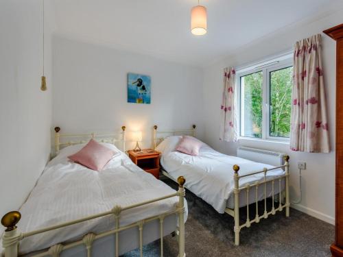 two beds in a bedroom with a window at 5 Bed in Holsworthy oc-79454 in Milton Damerel