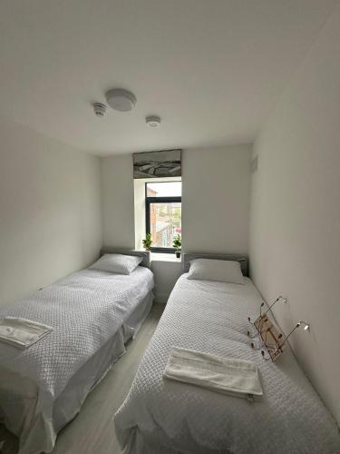 two beds in a room with a window at Milk Market Inn in Limerick