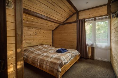 a bedroom with a bed in a log cabin at Guest House Plai in Yaremche