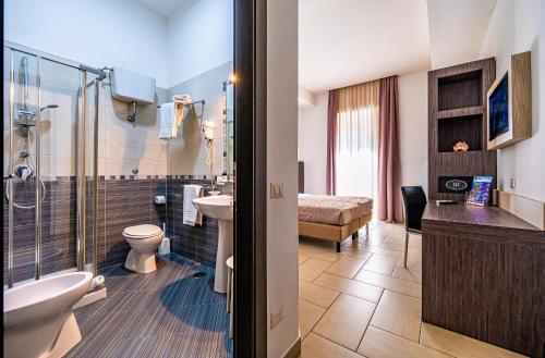 a bathroom with a toilet sink and a shower at Napoli Suite in Naples