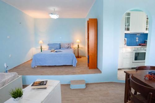 a blue bedroom with a bed and a kitchen at Dreamy View in Folegandros in Áno Meriá