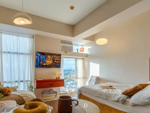 a living room with a bed and a large window at Condo in Cubao, Sunset & City Lights Chasing in Manila