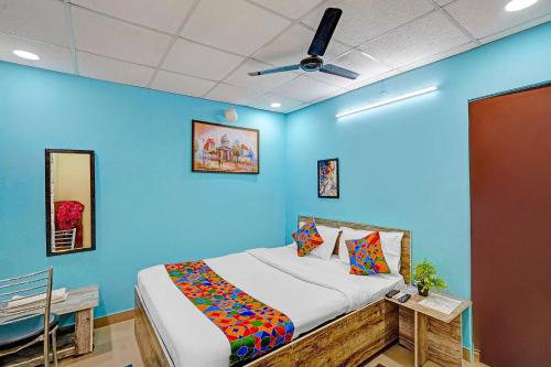 a bedroom with a bed in a blue wall at FabHotel The Radium Inn in Rānchī