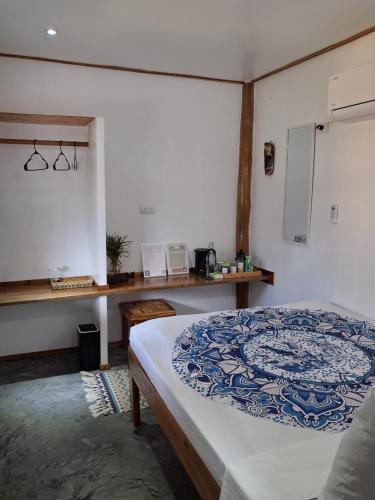a bedroom with a bed with a blue and white blanket at Sunset Garden in San Vicente