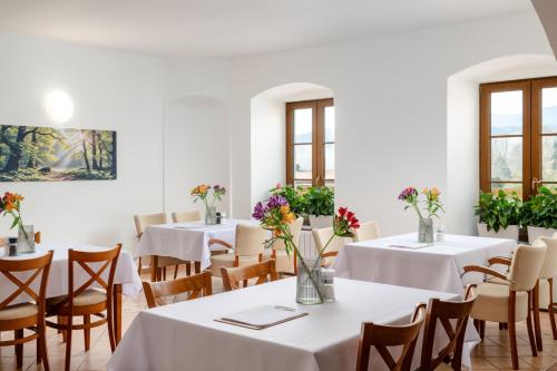 a dining room with tables and chairs with flowers on them at Hotel Pohoda in Staré Město