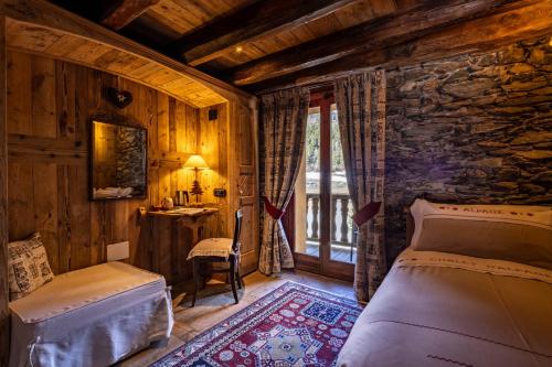a bedroom with a bed and a desk and a window at La Luge D'Antan Maison d'Hôtes & SPA in Brusson
