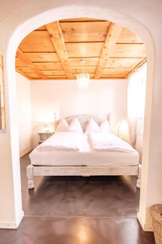 a bedroom with a white bed with a wooden ceiling at Surfers Sunset Spa with Jacuzzi & Panoramic Terrace in Grindelwald