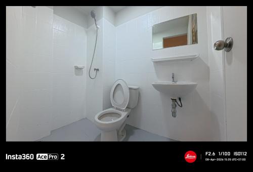a white bathroom with a toilet and a sink at My Space 77 in Ban Khlong Khwang Klang