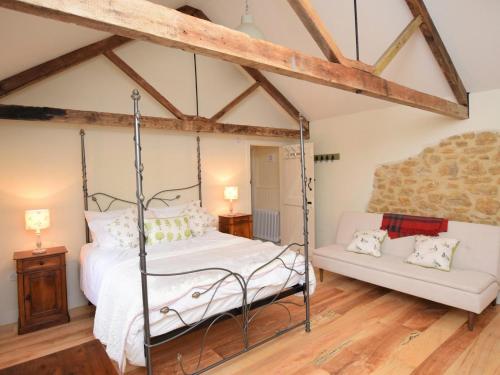 a bedroom with a four poster bed and a couch at 1 Bed in Stoke Abbott oc-50885 in Stoke Abbott