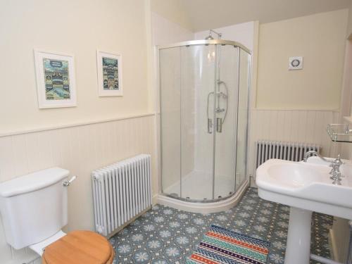 a bathroom with a shower and a toilet and a sink at 1 Bed in Stoke Abbott oc-50885 in Stoke Abbott
