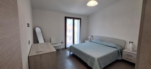 a bedroom with a bed and a dresser and a mirror at il PORTICO in Tertenìa