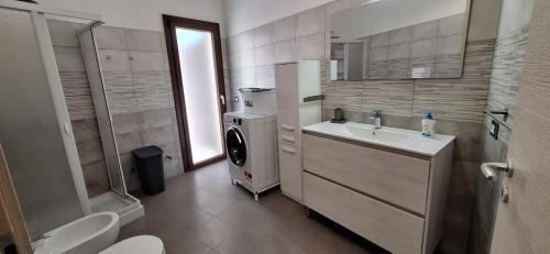 a bathroom with a sink and a washing machine at il PORTICO in Tertenìa