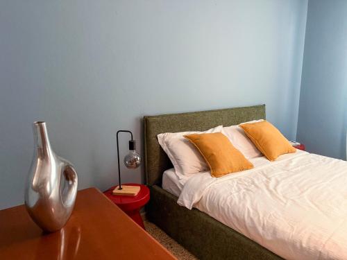 a bedroom with a bed with orange pillows and a table at Casa Lagò Lagò Panoramic Apartment in Ranzanico