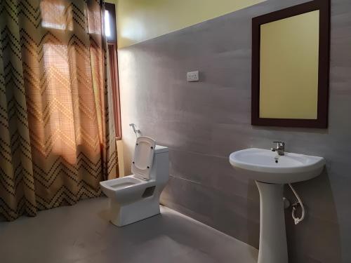 a bathroom with a toilet and a sink at Transit Motel Ukonga in Dar es Salaam