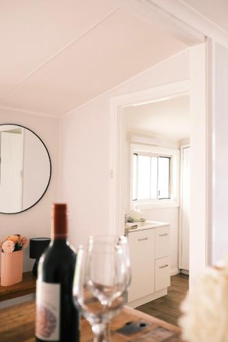 a bottle of wine and a wine glass on a table at Longford Cottage in Longford
