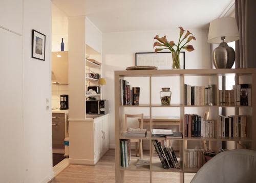 Le Studio 1517 في لو كرملين-بيستر: غرفة معيشة مع رف للكتب مليئ بالكتب