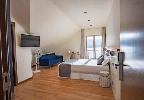 a hotel room with a bed and a tv at Alda Corcubión in Corcubión