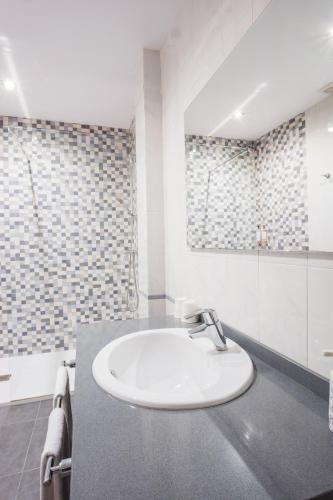 a white bathroom with a sink and a shower at Alda Corcubión in Corcubión