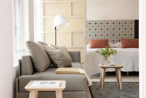 a living room with a couch and a bed at Eric Vökel Boutique Apartments - Copenhagen Suites in Copenhagen
