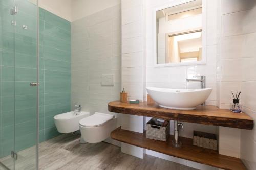 a bathroom with a sink and a toilet and a mirror at Casetta sulla Spiaggia - HelloElba in Capoliveri