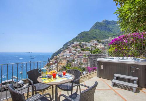 a balcony with a table and chairs and the ocean at Hotiday Positano Volte Alte in Positano