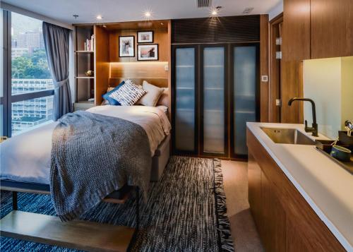 a bedroom with a bed and a sink and a tub at Oootopia West in Hong Kong