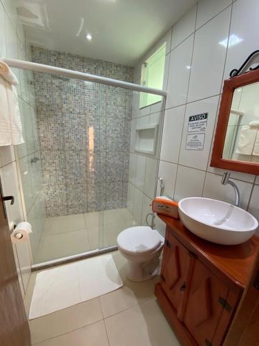 a bathroom with a shower and a toilet and a sink at Pousada No Alto da Serra Conservatória in Conservatória
