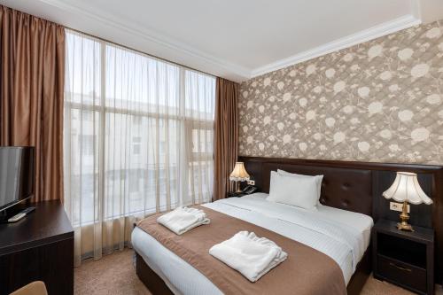 a bedroom with a bed and a large window at Kalasi Hotel in Tbilisi City